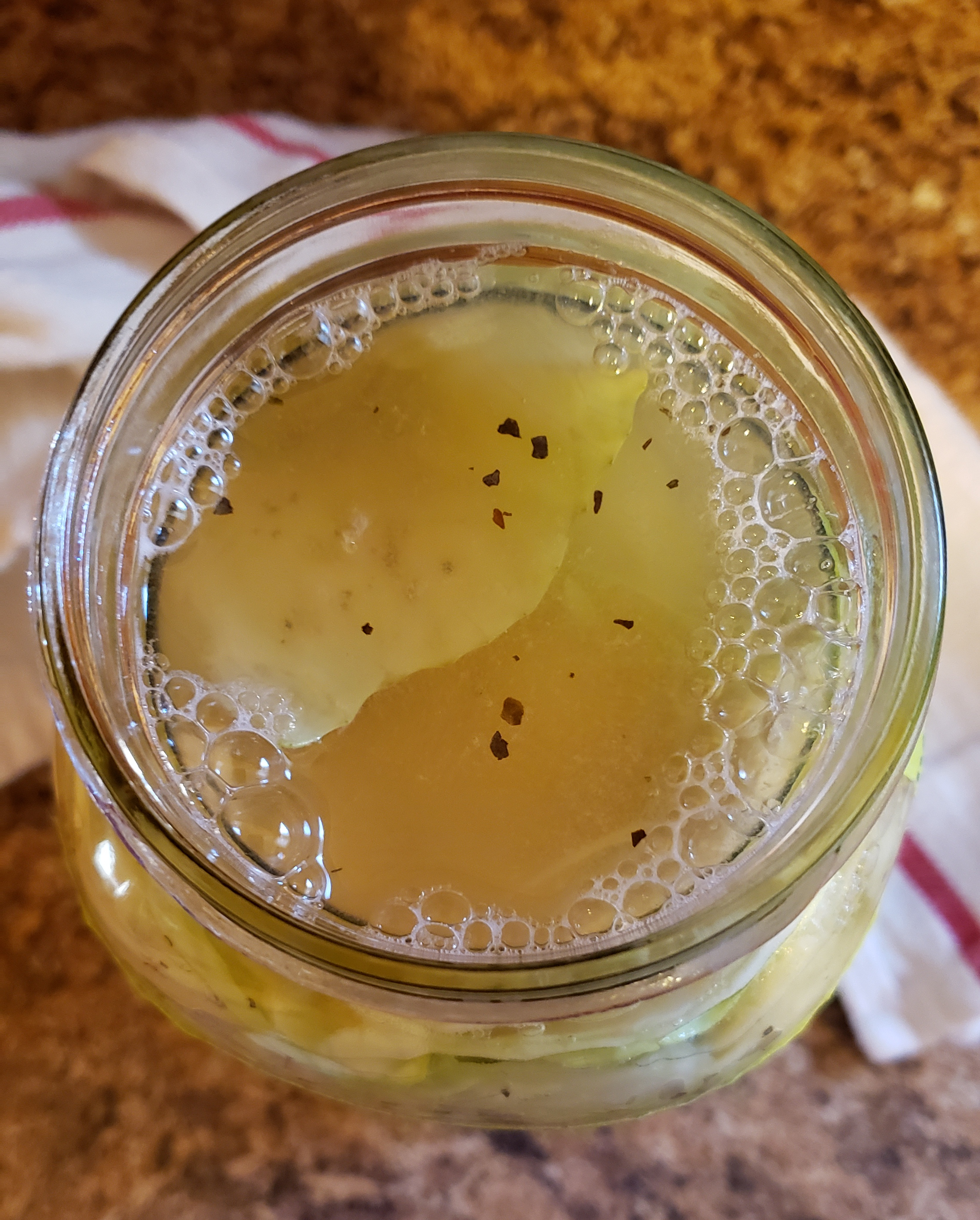 A top down view of the jar without the lid on. The water level is near the top and there are bubbles on the surface.